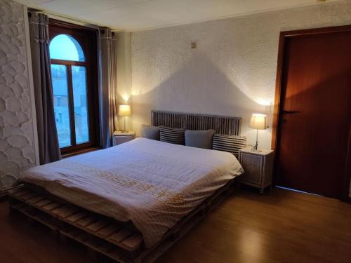 希迈Appartement cosy à Chimay的一间卧室配有一张大床和两盏灯。