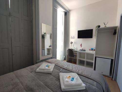 布拉加Vila Santa Cruz Guest House的一间卧室配有一张床,上面有两条毛巾