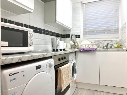 伦敦Park West Apartment的白色的厨房配有洗衣机和水槽