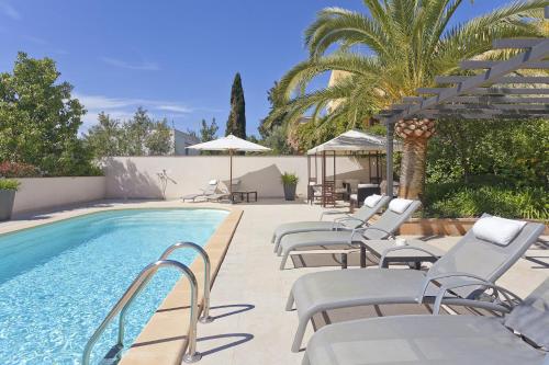 马略卡岛帕尔马Guesthouse Palma - Suite Arabella Apartment, Adults Only的游泳池旁设有躺椅和遮阳伞