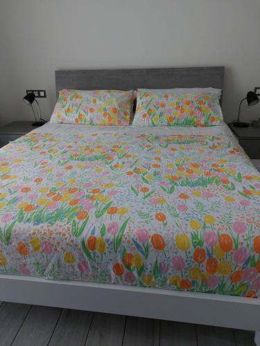 GozzanoSkylab的一张带五颜六色床罩的床上,上面有鲜花