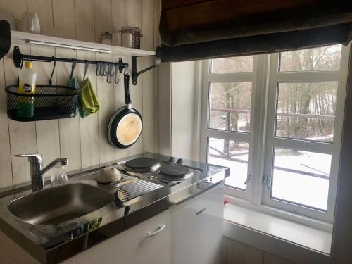 VinjeøraGrønset Skysstasjon的厨房配有水槽、炉灶和窗户。