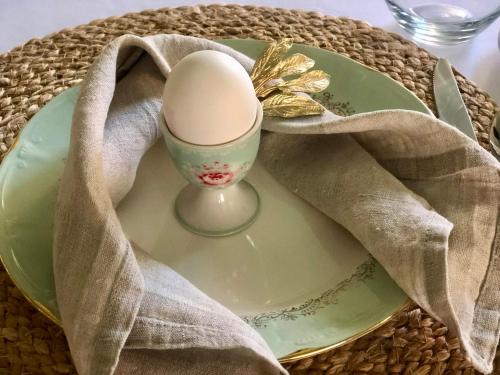 VinjeøraGrønset Skysstasjon的一只蛋坐在带餐巾的盘子里