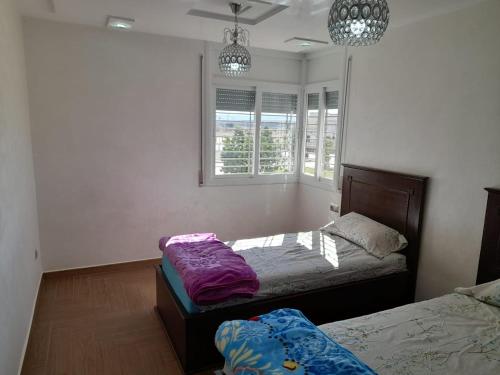 纳祖尔appartement NADOR wifi gratuit的一间卧室设有两张床和两个窗户。