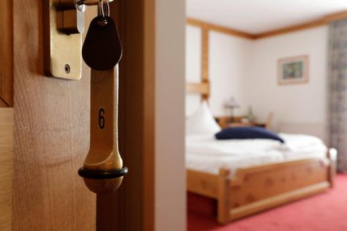 阿尔肯温泽霍夫布拉赫滕多夫酒店的卧室的门,卧室内有一张床
