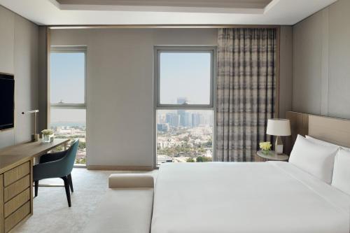 阿布扎比InterContinental Residences Abu Dhabi, an IHG Hotel的酒店客房设有一张大床、一张书桌和窗户。