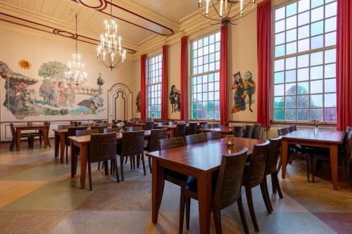 西姆斯科克Stayokay Hostel Heemskerk的用餐室设有桌椅和窗户。