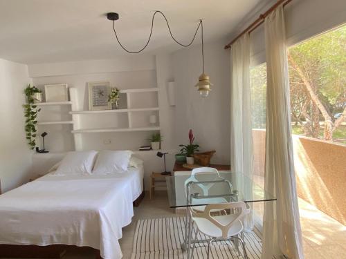 埃斯普霍斯CALMA Es Pujols的一间卧室配有两张床和一张玻璃桌