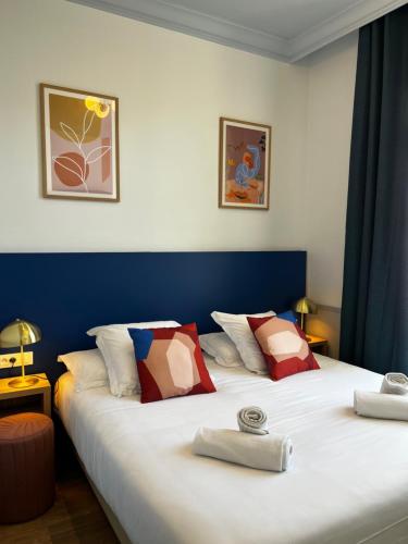 芒通伦敦酒店的配有2张床的蓝色和白色墙壁客房