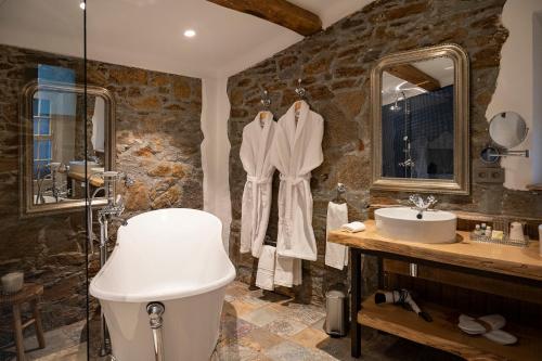 格里莫Le Clos de Mansart的石质浴室设有水槽和淋浴。