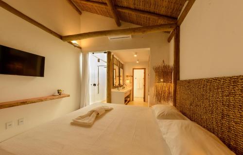 库穆鲁沙蒂巴Pousada Nossa Casa Cumuruxatiba的一间卧室配有一张床,床上有毛巾