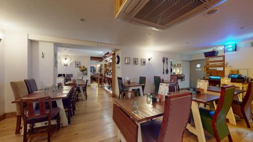 EckingtonThe Devonshire Arms的用餐室配有木桌和椅子