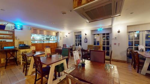 EckingtonThe Devonshire Arms的一间在房间内配有桌椅的餐厅