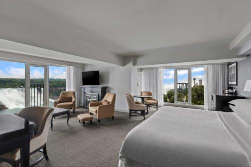 尼亚加拉瀑布Sheraton Fallsview Hotel的酒店客房,配有一张床、一张桌子和椅子