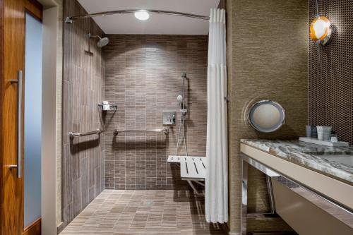 奥斯汀奥斯汀JW万豪酒店的浴室设有步入式淋浴间,毗邻水槽