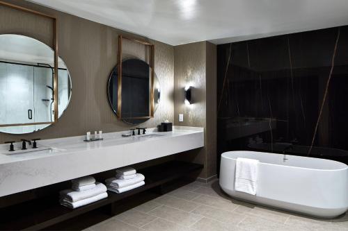 夏洛特UNC Charlotte Marriott Hotel & Conference Center的一间带大浴缸和大镜子的浴室