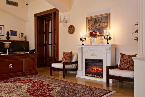 布拉格FLEUR DE LIS HOTEL的客厅设有壁炉和2把椅子