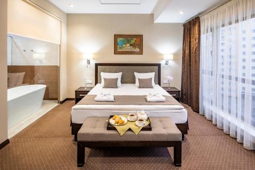 利沃夫陶鲁斯Spa酒店的酒店客房配有一张床和浴缸。