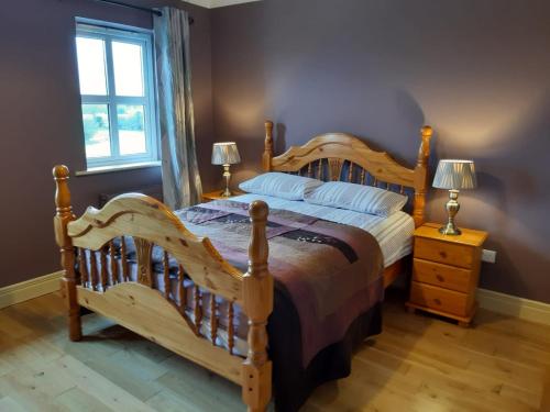 康镇Whitethorn Lodge, Bed & Breakfast, Lackafinna的一间卧室设有一张大型木床和一个窗户。