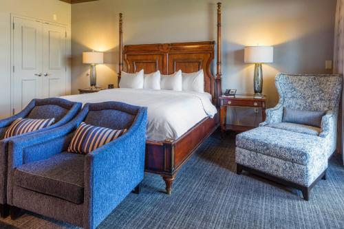 欧佩莱卡Auburn Marriott Opelika Resort & Spa at Grand National的酒店客房,配有一张床和两把椅子