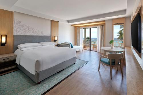 芭东海滩Phuket Marriott Resort & Spa, Merlin Beach的一间卧室配有一张大床和一张书桌