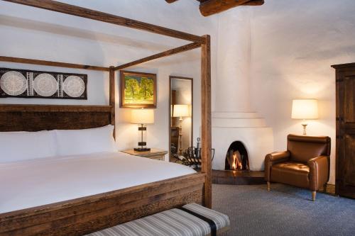圣达菲圣菲拉波萨达德Spa度假酒店的一间卧室配有一张床、一把椅子和一个壁炉