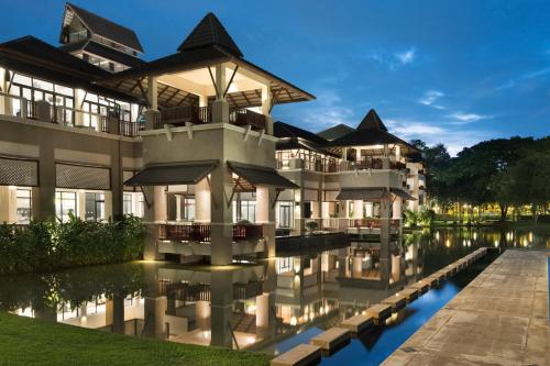 清莱Le Meridien Chiang Rai Resort, Thailand的享有带池塘的建筑的外部景色