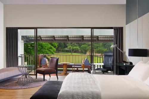 清莱Le Meridien Chiang Rai Resort, Thailand的一间卧室设有一张床和一间客厅。