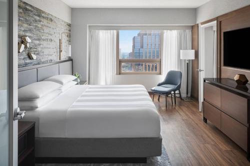 明尼阿波利斯明尼阿波利斯市中心万豪酒店的酒店客房设有一张大床和一台电视。