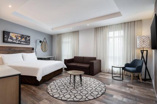 约翰内斯堡普罗提流浪者酒店的配有一张床和一把椅子的酒店客房