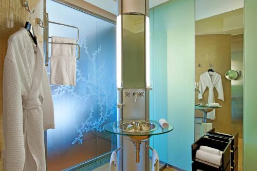蒙特卡罗艾美度假酒店的一间带玻璃桌和淋浴的浴室