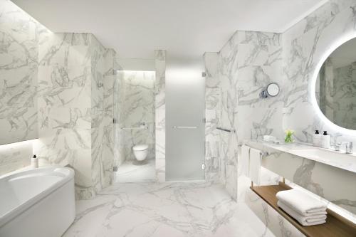 阿布扎比InterContinental Residences Abu Dhabi, an IHG Hotel的带淋浴和盥洗盆的白色浴室