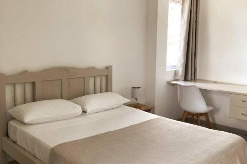 CurepipeLa Péninsule - Town Apartment No. 3的卧室配有白色的床和窗户。
