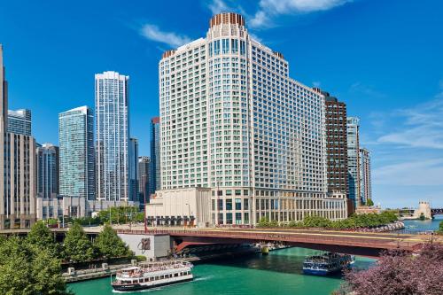 芝加哥Sheraton Grand Chicago Riverwalk的一座高大的建筑,有一座河上的桥梁