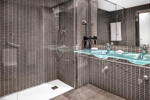 维多利亚-加斯特伊兹B&B HOTEL Vitoria General Álava的一间带玻璃淋浴和水槽的浴室