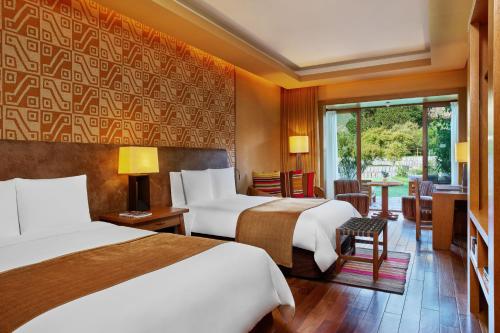 乌鲁班巴Tambo del Inka, a Luxury Collection Resort & Spa, Valle Sagrado的酒店客房设有两张床和窗户。