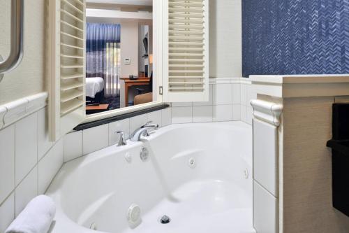 卡皮托拉桑塔克鲁兹费尔菲尔德客栈及套房酒店 - 卡皮托拉的带窗户的浴室内的白色浴缸