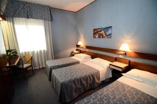 萨尔扎纳奥圣安德烈亚酒店的酒店客房设有两张床和窗户。