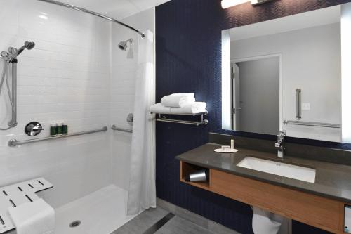MoorparkFairfield Inn & Suites by Marriott Moorpark Ventura County的带浴缸、水槽和镜子的浴室