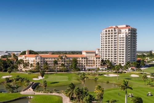 阿文图纳JW Marriott Miami Turnberry Resort & Spa的享有度假村高尔夫球场的景色,拥有一座高高的建筑