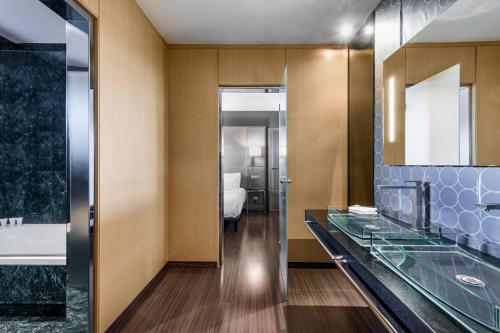 拉科鲁尼亚AC Hotel A Coruña by Marriott的一间带玻璃台面和浴缸的浴室