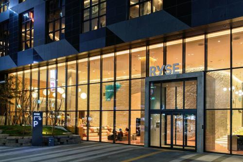 首尔RYSE, Autograph Collection, Seoul的大楼前方的商店,设有大型玻璃窗