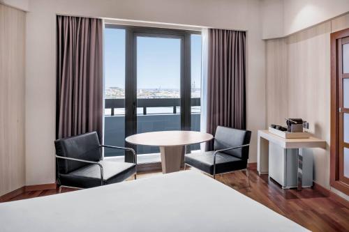大加那利岛拉斯帕尔马斯大加那利万豪AC酒店的酒店客房设有桌椅和窗户。
