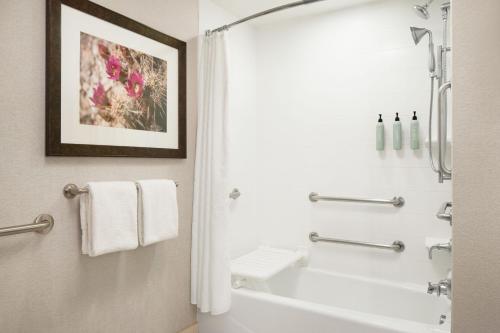 斯科茨斯科特斯盐河万怡酒店的浴室配有白色浴缸和淋浴。