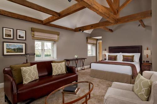 艾弗The Langley, a Luxury Collection Hotel, Buckinghamshire的一间卧室配有一张特大号床和一张沙发