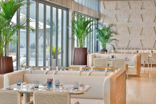 迪拜The St. Regis Dubai, The Palm的餐厅设有桌椅和大窗户。