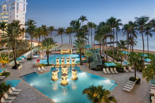圣胡安圣胡安万豪度假及斯特拉瑞斯娱乐场酒店的享有棕榈树度假村泳池的顶部景致