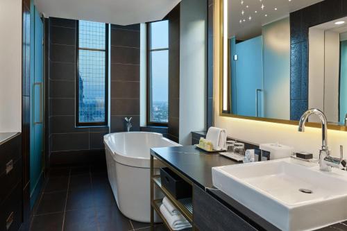明尼阿波利斯威明普利斯酒店 - 富沙的带浴缸、水槽和镜子的浴室