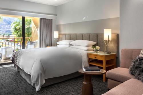 棕榈泉棕榈泉万丽酒店的酒店客房设有一张大床和一张沙发。