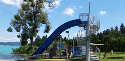 沃尔特湖畔韦尔登Ferienwohnung Schellander Privatstrand的水边公园的蓝色滑梯